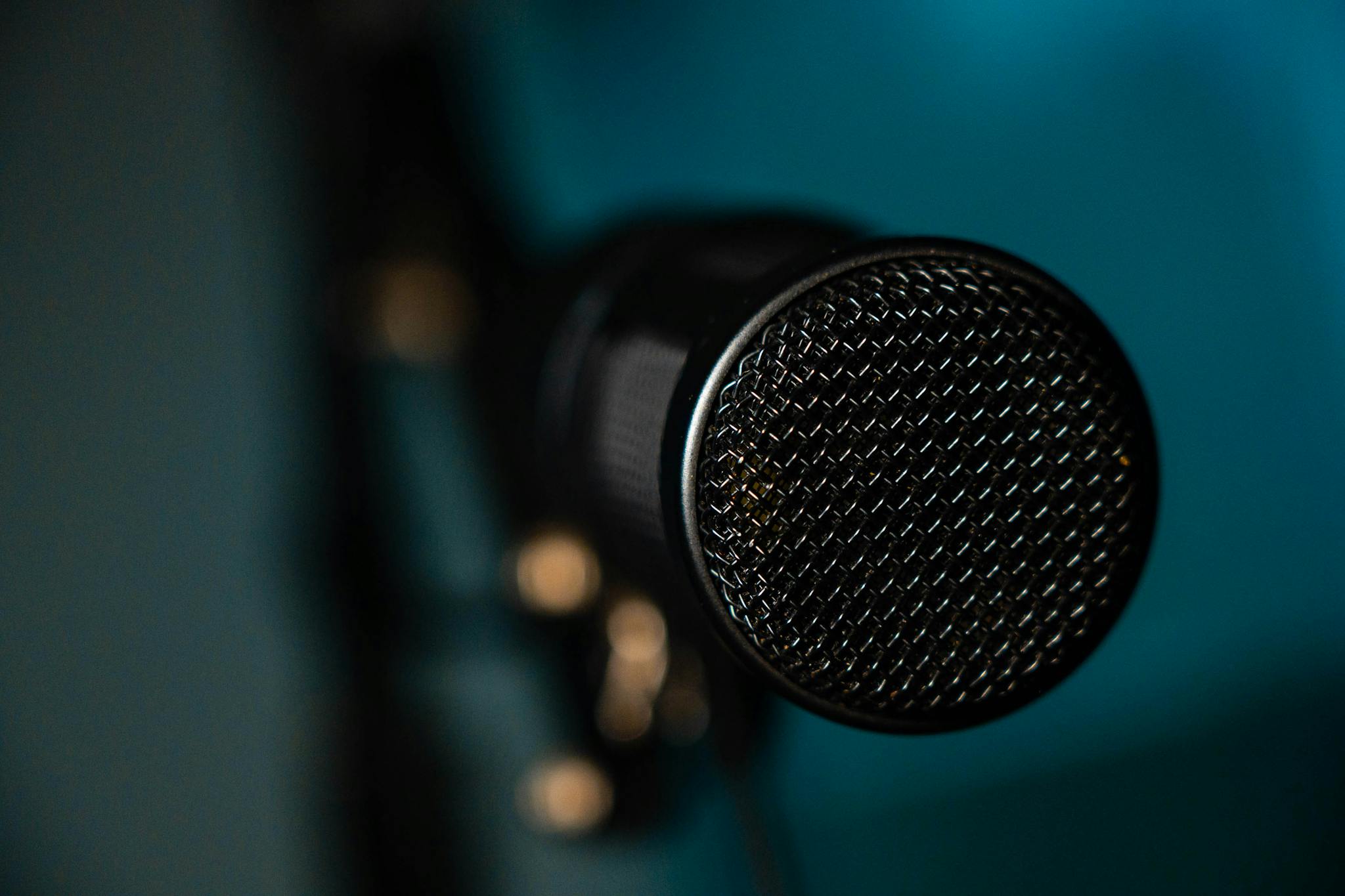 Detailed image of a black microphone with selective focus in a studio environment.